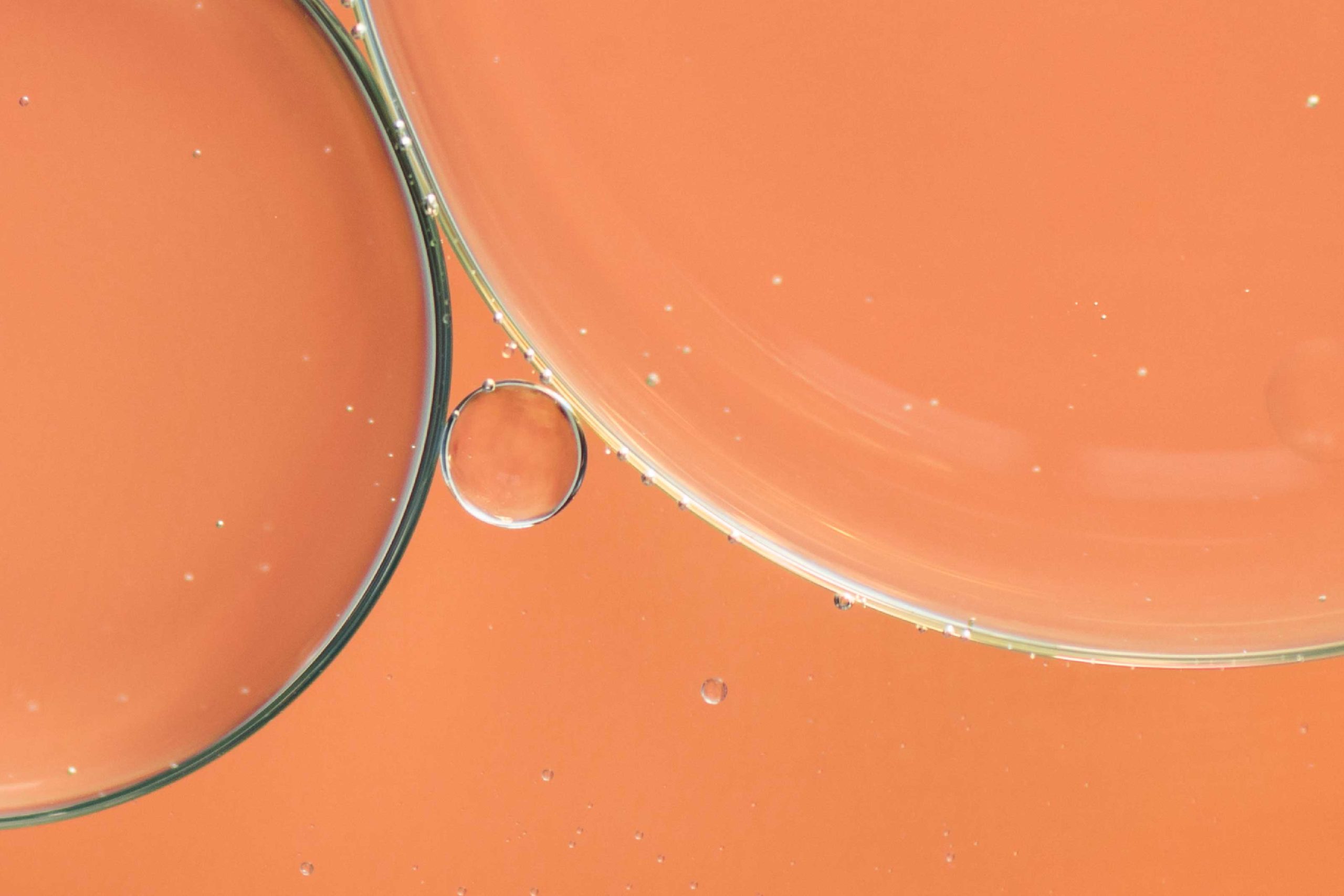 Bolas de gás em líquido laranja em primeiro plano