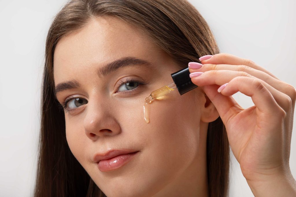 Mulher aplicando sérum facial com conta-gotas